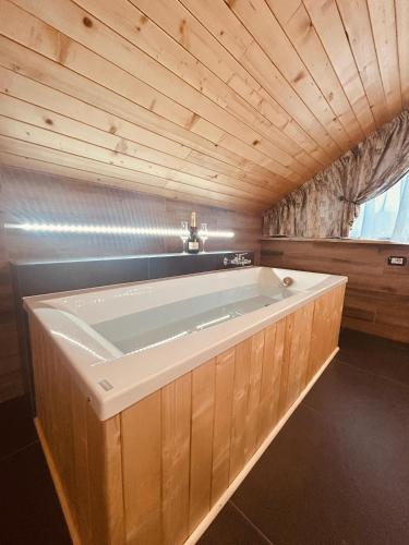 a large bath tub in a room with a wooden ceiling at CABANA GOTAN in Moisei