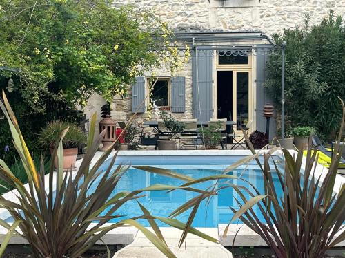- une piscine en face d'une maison ornée de plantes dans l'établissement Maison en Provence, à Lapalud