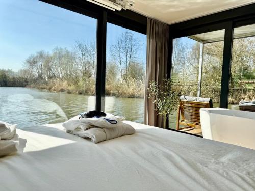 une chambre avec un lit avec vue sur l'eau dans l'établissement La Dolce Vita ! Sauna, Spa, Cinéma, à Basse-Ham