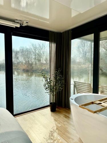 - une chambre avec une baignoire et une vue sur l'eau dans l'établissement La Dolce Vita ! Sauna, Spa, Cinéma, à Basse-Ham