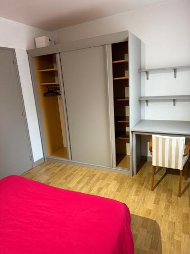 une chambre avec un lit rouge et un miroir dans l'établissement Appartement 2 pièces vue sur la rivière de l'Aven et le Bois d Amour, à Pont-Aven