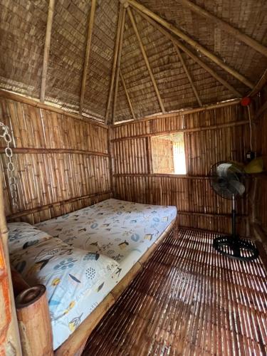 una camera con un letto in una capanna di paglia di Sharky Hostel Oslob a Oslob