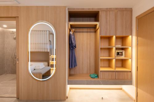 a bathroom with a mirror and a bed in a room at Jomtien Thani Hotel in Jomtien Beach