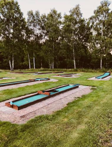 a row of water slides in a grass field at Modern villa med spa och pool in Skäralid