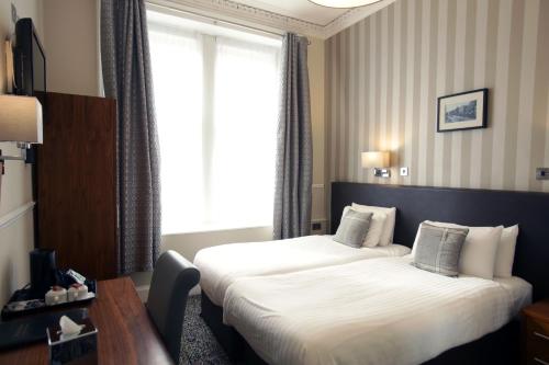 a hotel room with two beds and a window at Kelvingrove Hotel - Sauchiehall St in Glasgow
