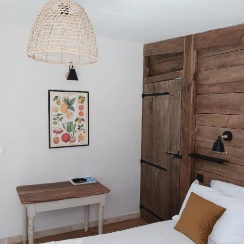 - une chambre avec un lit doté d'une porte en bois et d'une table dans l'établissement La Tour du Laurensou, à Figeac