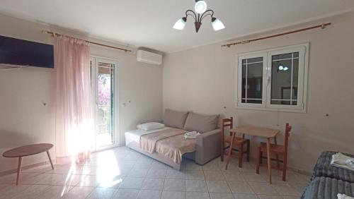 a bedroom with a bed and a table and chairs at Rena Studios in Paleokastritsa