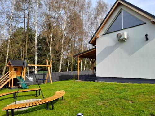 a house with a playground in the yard at Świtówka Wiktorowo in Żnin
