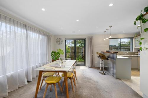 a dining room with a table and yellow chairs at Urban and Stunning 3 bed Home in Hutt Central in Lower Hutt