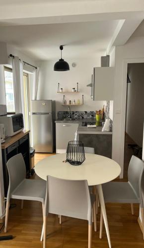 une cuisine avec une table et des chaises dans une pièce dans l'établissement APPARTEMENT CENTRE-Bastia à une minute à pied du port, à Bastia