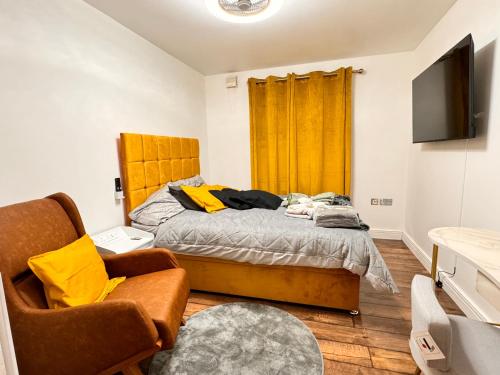 a bedroom with a bed and a tv and a chair at ABBAccommodation in London