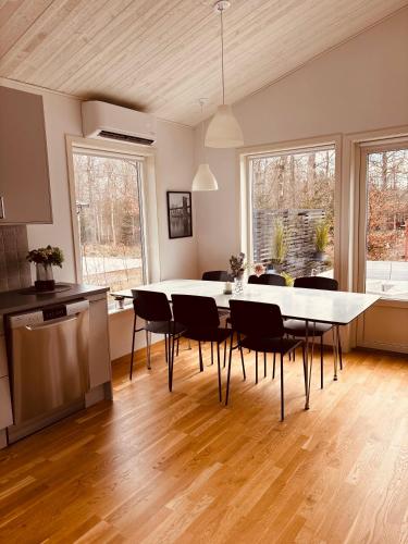a kitchen and dining room with a table and chairs at Modern villa med spa och pool in Skäralid
