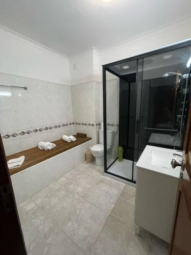 a bathroom with a shower and a toilet and a sink at cantinho do mar in Albufeira