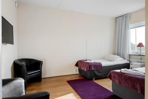 a hotel room with two beds and a chair at Sure Hotel by Best Western Ojaby Herrgard in Växjö