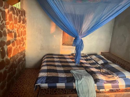 a bedroom with a bed with a blue curtain at Island Life Bungalows in Ko Khan