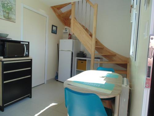 Cette chambre dispose d'une table et d'un escalier avec des chaises bleues. dans l'établissement Monteval, à Saint-Malo