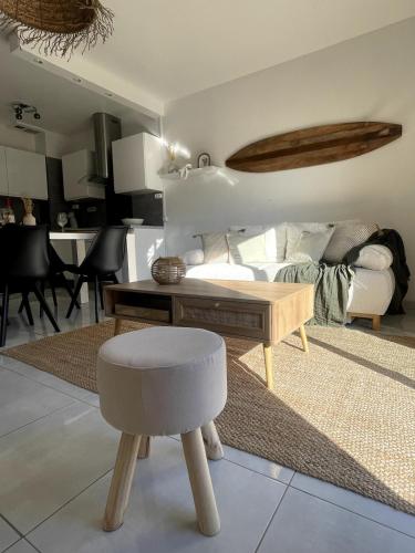 - un salon avec un canapé, une table et un tabouret dans l'établissement Les Sables de Pami, à Narbonne