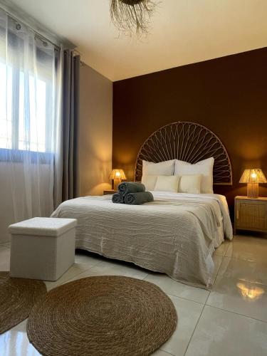 une chambre avec un grand lit et une grande fenêtre dans l'établissement Les Sables de Pami, à Narbonne