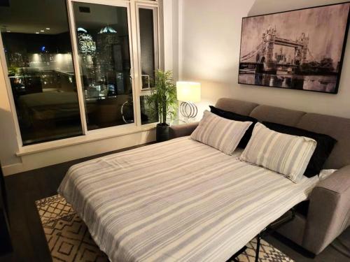 a bed in a room with a large window at Breath Taking View-4Guest DT Skyline 35th Floor in Calgary