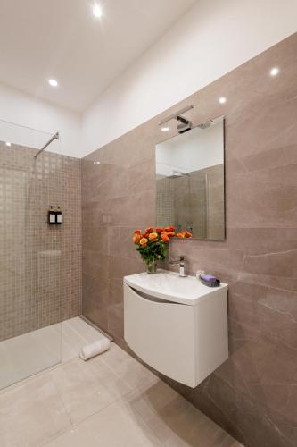 a bathroom with a white sink and a mirror at Genoa Lux Apartments with parking in Genova
