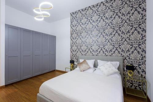 a bedroom with a white bed and a blue and white wall at Genoa Lux Apartments with parking in Genova