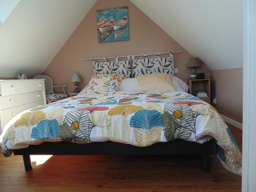 une chambre avec un lit avec une couette colorée dans l'établissement Monteval, à Saint-Malo