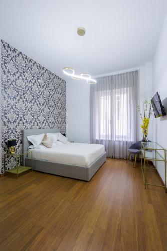 a white bedroom with a bed and a table at Genoa Lux Apartments with parking in Genova
