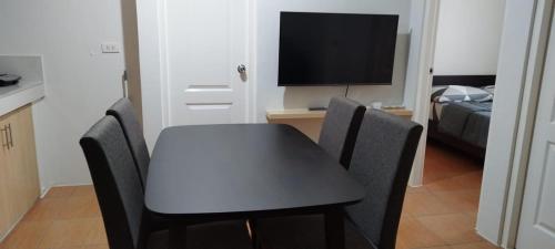 a dining table with chairs and a television in a room at San Remo Oasis in Cebu City