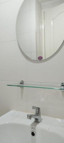 a mirror over a white sink with a mirror above it at San Remo Oasis in Cebu City