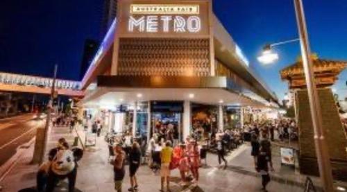a crowd of people walking in front of a metro building at Broadwater Parklands Paradise in Gold Coast