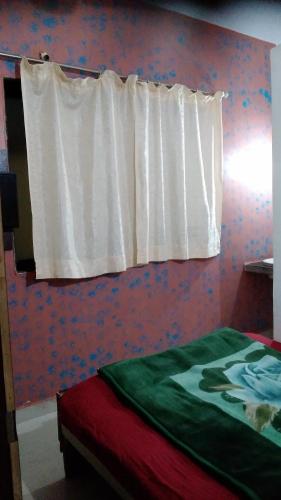 a bedroom with a bed with a white curtain at Om Datta Krupa Niwas Cottage in Mahabaleshwar