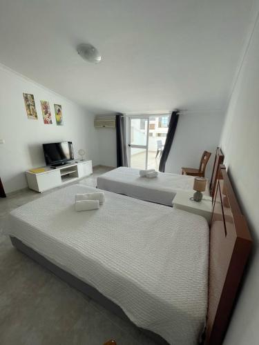 a bedroom with two twin beds and a television at studio para 2 pessoas in Albufeira