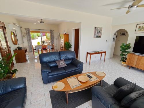a living room with a couch and a table at Villa Best Holiday- breathtaking sea views, amazing garden, private pool, BBQ, next to CORAL BAY, Lower Peyia, Paphos in Peyia