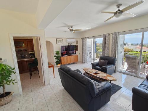 a living room with two couches and a table at Villa Best Holiday- breathtaking sea views, amazing garden, private pool, BBQ, next to CORAL BAY, Lower Peyia, Paphos in Peyia