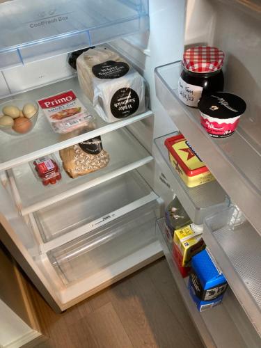 an open refrigerator filled with food and other food items at Captains Cottage - Pet Friendly Breakfast Included in Goolwa