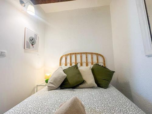 - une chambre avec un lit doté d'oreillers verts et blancs dans l'établissement Chez Gala, à Collioure