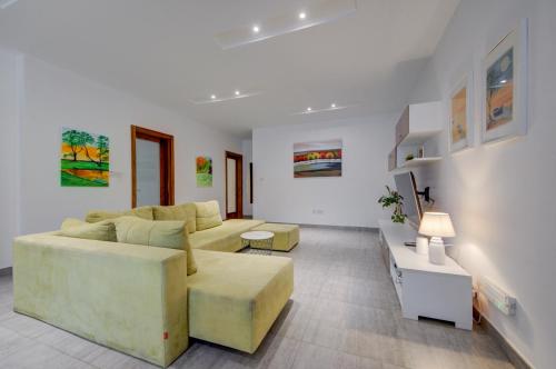 a living room with a couch and a table at Top floor apt with common pool close to all amenities in St. Paul's Bay