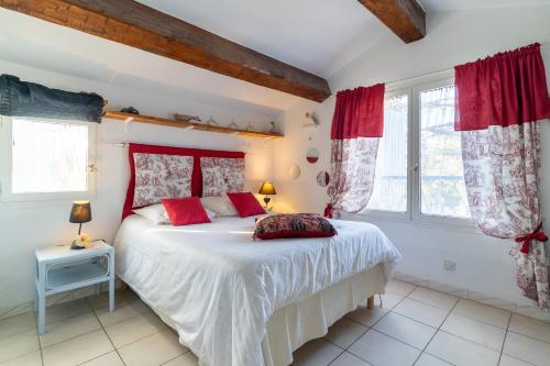 - une chambre avec un grand lit et des rideaux rouges dans l'établissement MAISON DE CHARME PRES de la MER CLIMATISEE, à Saint-Cyr-sur-Mer