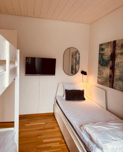 a bedroom with a bed and a tv on the wall at Modern villa med spa och pool in Skäralid
