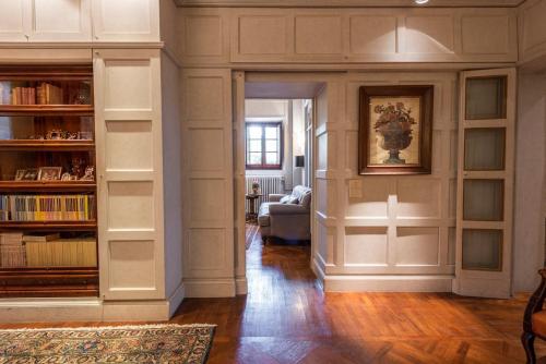a living room with white walls and bookshelves at Villa Riflessi di Fiesole - Piscina - Vista Firenze in Fiesole