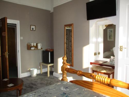 a bedroom with a bed and a mirror and a television at Ashwood Grange in Torquay