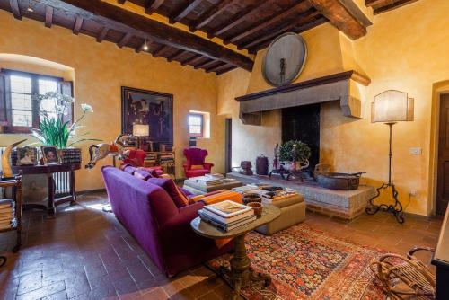 a living room with a couch and a fireplace at Villa Riflessi di Fiesole - Piscina - Vista Firenze in Fiesole
