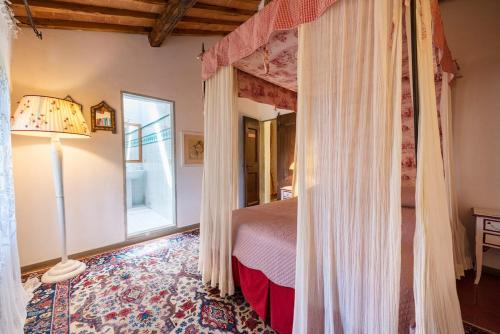 a bedroom with a canopy bed and a window at Villa Riflessi di Fiesole - Piscina - Vista Firenze in Fiesole