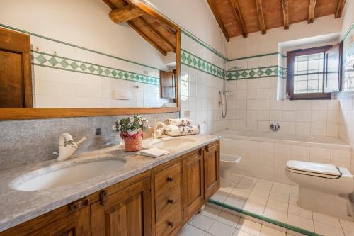 a bathroom with a sink and a tub and a toilet at Villa Riflessi di Fiesole - Piscina - Vista Firenze in Fiesole