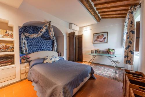 a bedroom with a bed and a table in it at Villa Riflessi di Fiesole - Piscina - Vista Firenze in Fiesole