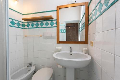 a bathroom with a sink and a toilet and a mirror at Villa Riflessi di Fiesole - Piscina - Vista Firenze in Fiesole