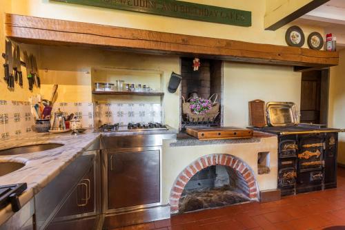 a kitchen with a stove and a fireplace in it at Villa Riflessi di Fiesole - Piscina - Vista Firenze in Fiesole