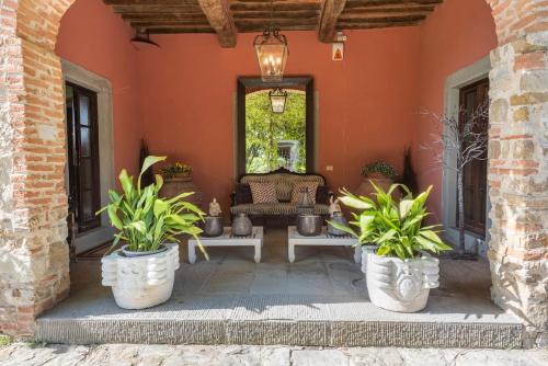 a patio with potted plants in front of a building at Villa Riflessi di Fiesole - Piscina - Vista Firenze in Fiesole