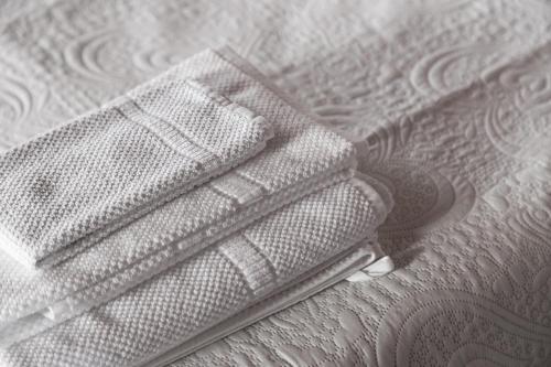 a stack of white sheets on a bed at Villa Riflessi di Fiesole - Piscina - Vista Firenze in Fiesole