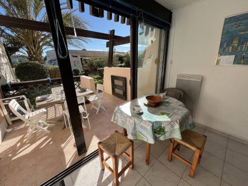 une salle à manger avec une table et des chaises sur un balcon dans l'établissement Studio cabine 2 couchages CAP D'AGDE NATURISME CN020-009, au Cap d'Agde